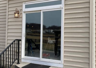 White sliding glass door leading to backyard